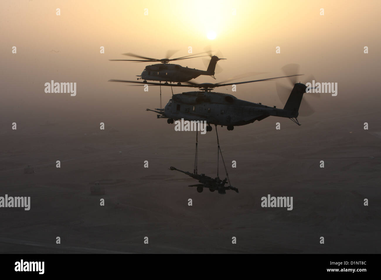 Due Stati Uniti Marine Corps CH-53E Super stalloni con Marine elicottero pesante Squadron (HMH) 361, Marine Aircraft Group 16, terzo aeromobile Marina Wing (avanti), sollevamento esterno M777 obici sulla provincia di Helmand, Afghanistan, Dic 29, 2012. HMH-361 fornito Foto Stock