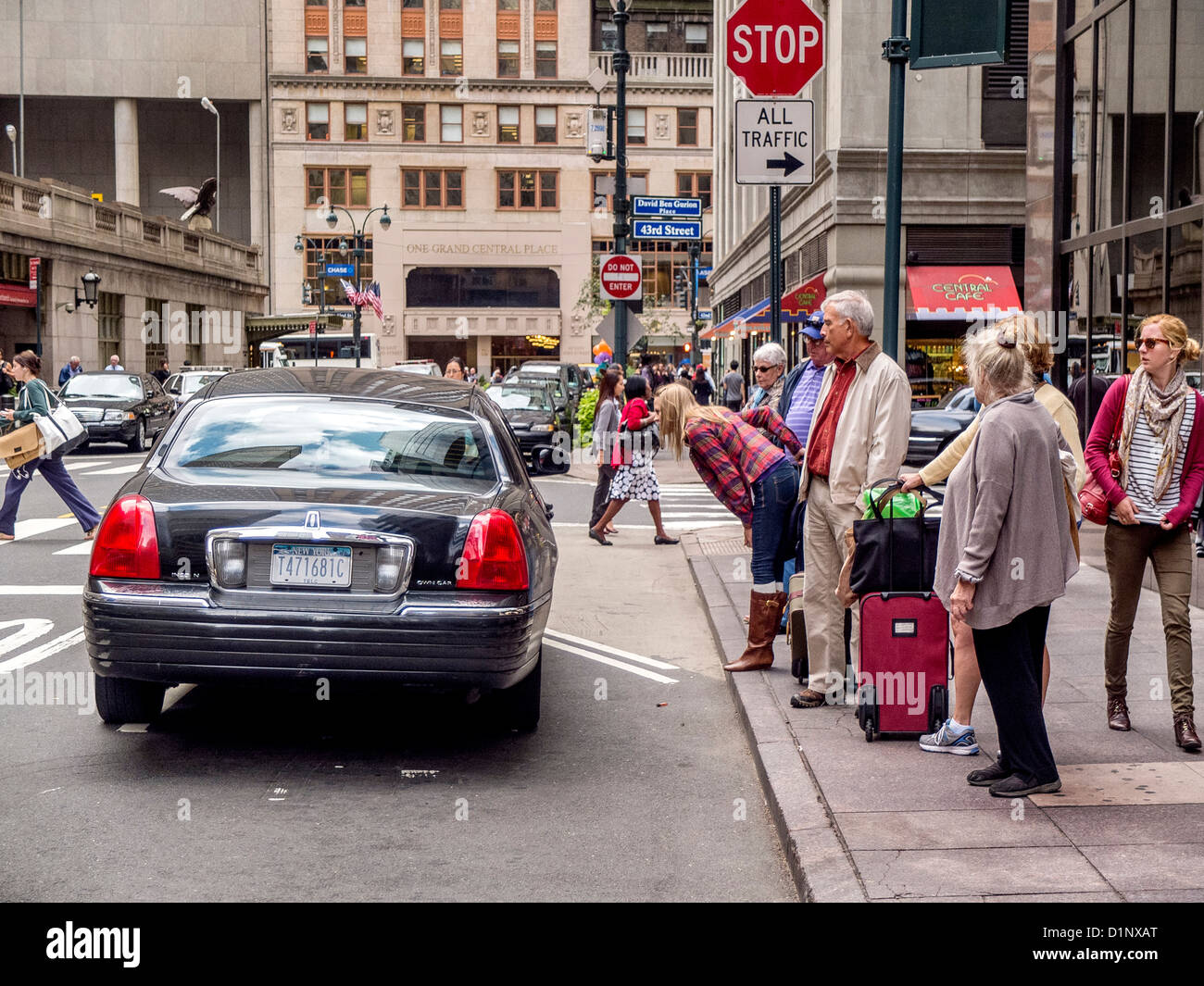 Un tetro-Cerca gruppo di nuovi arrivati i viaggiatori attendere sul marciapiede al di fuori di New York Grand Central Station, Foto Stock