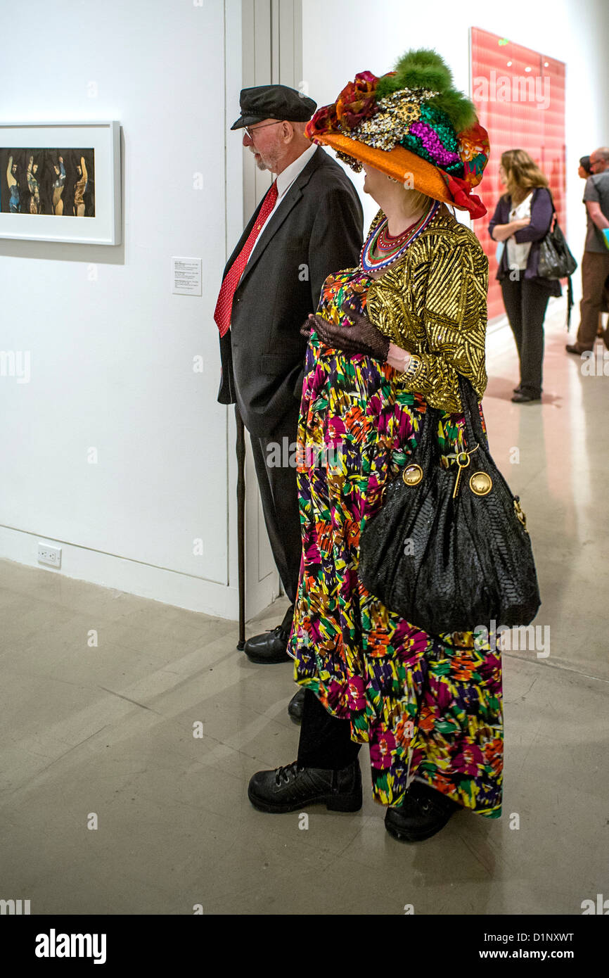 Un vestito in maniera colorata coppia di anziani assistere ad un'arte mostra museo apertura notturna e la ricezione in Newport Beach, CA Foto Stock