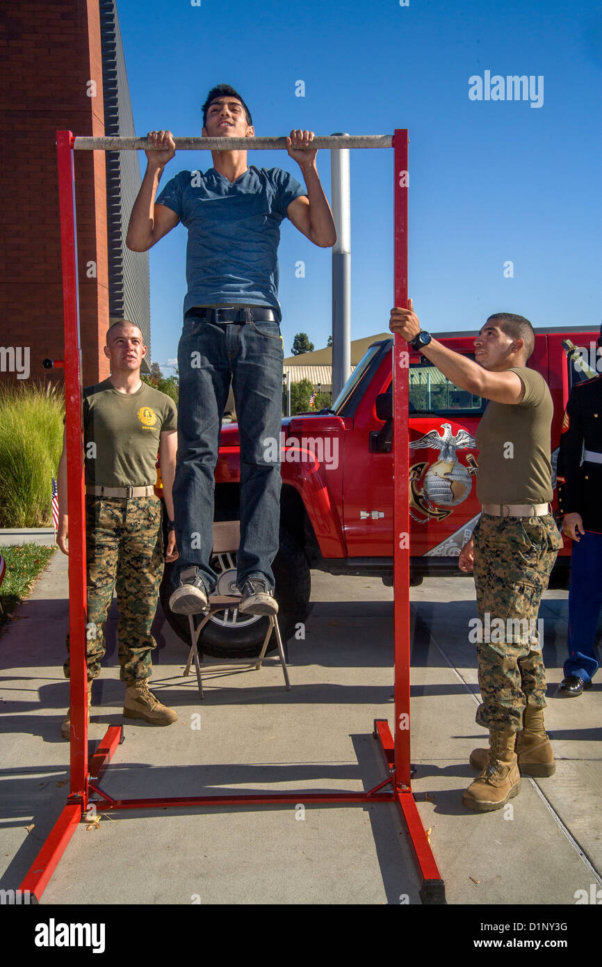 Una comunità studente di college mette in mostra la sua maestria del chin ups a una coppia di stati uniti Marines presso una unità di reclutamento a Irvine, CA. Foto Stock