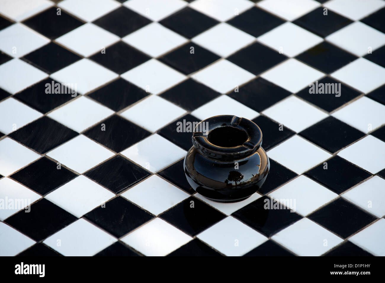 Ceramica Nera sul posacenere a quadretti o a scacchi in piastrelle bianche e nere tabella Foto Stock