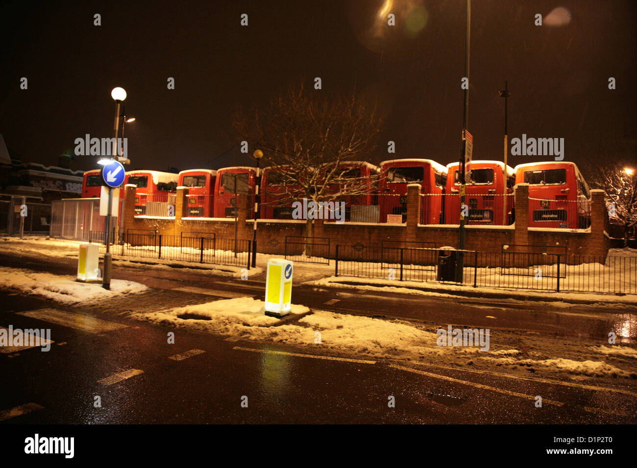 Neve coperto rosso Londra autobus parcheggiati in corsia di cancelletto Foto Stock