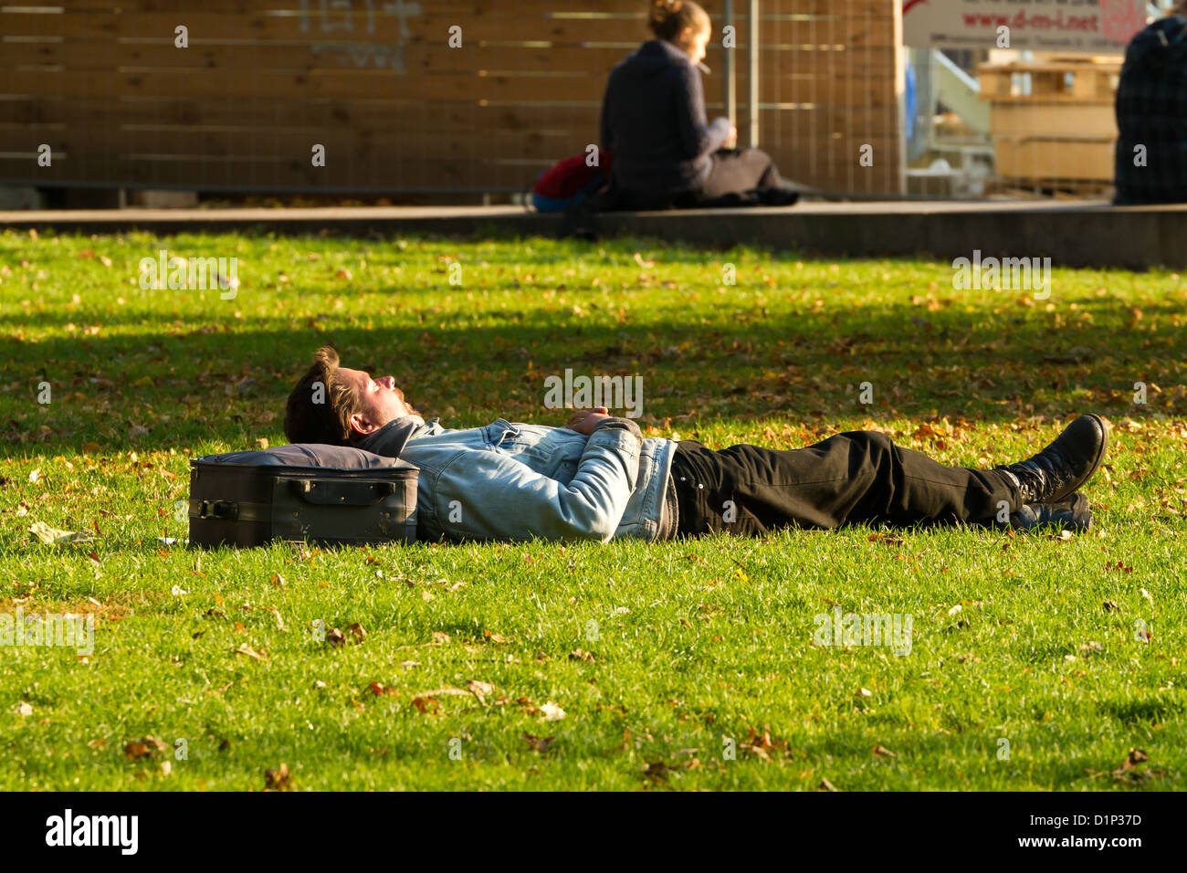 L'uomo avente un pisolino nel Monbijou Park a Berlino, Germania Foto Stock