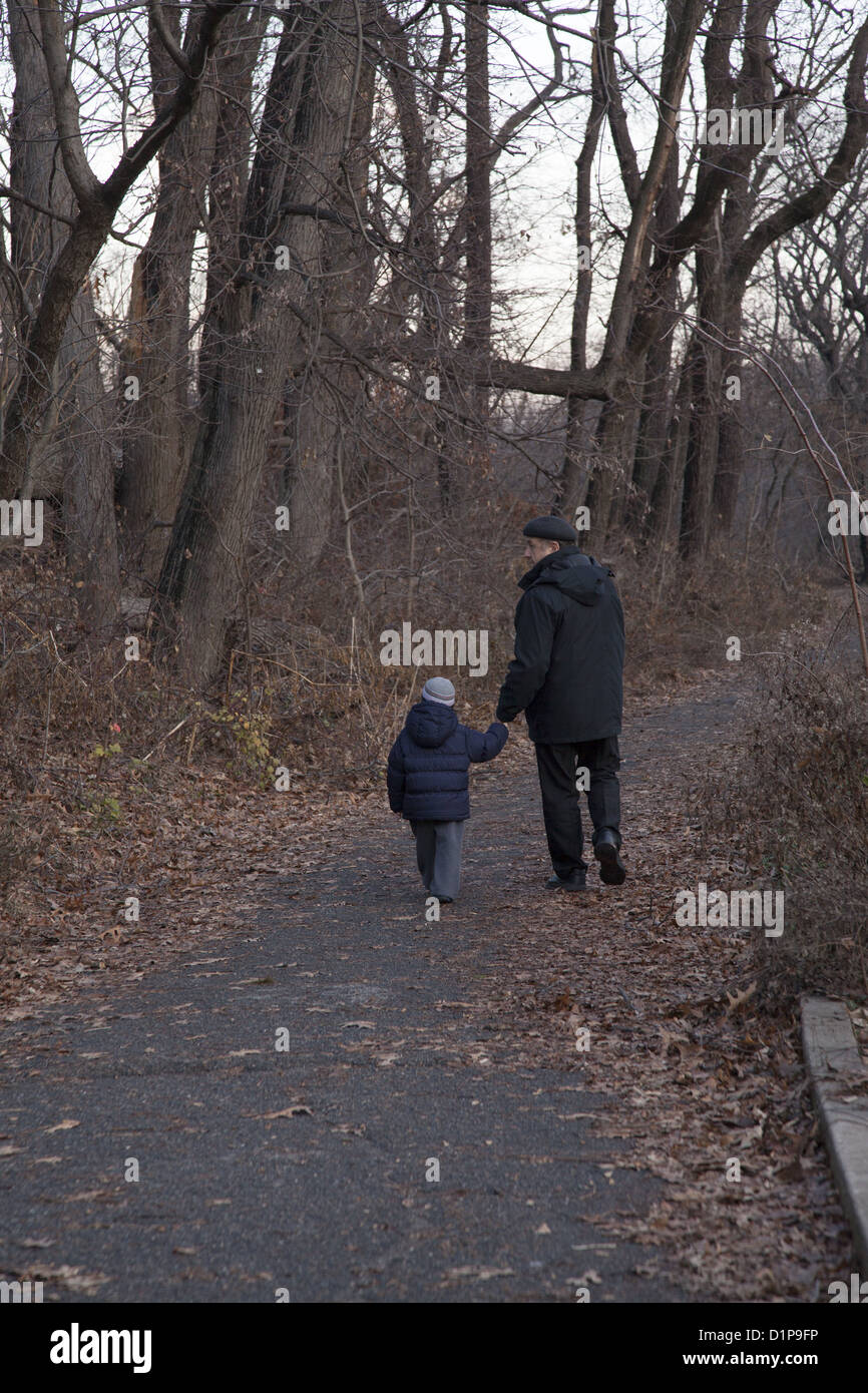 Il nonno e nipote a piedi tra gli alberi in inizio inverno a Prospect Park di Brooklyn, New York. Foto Stock