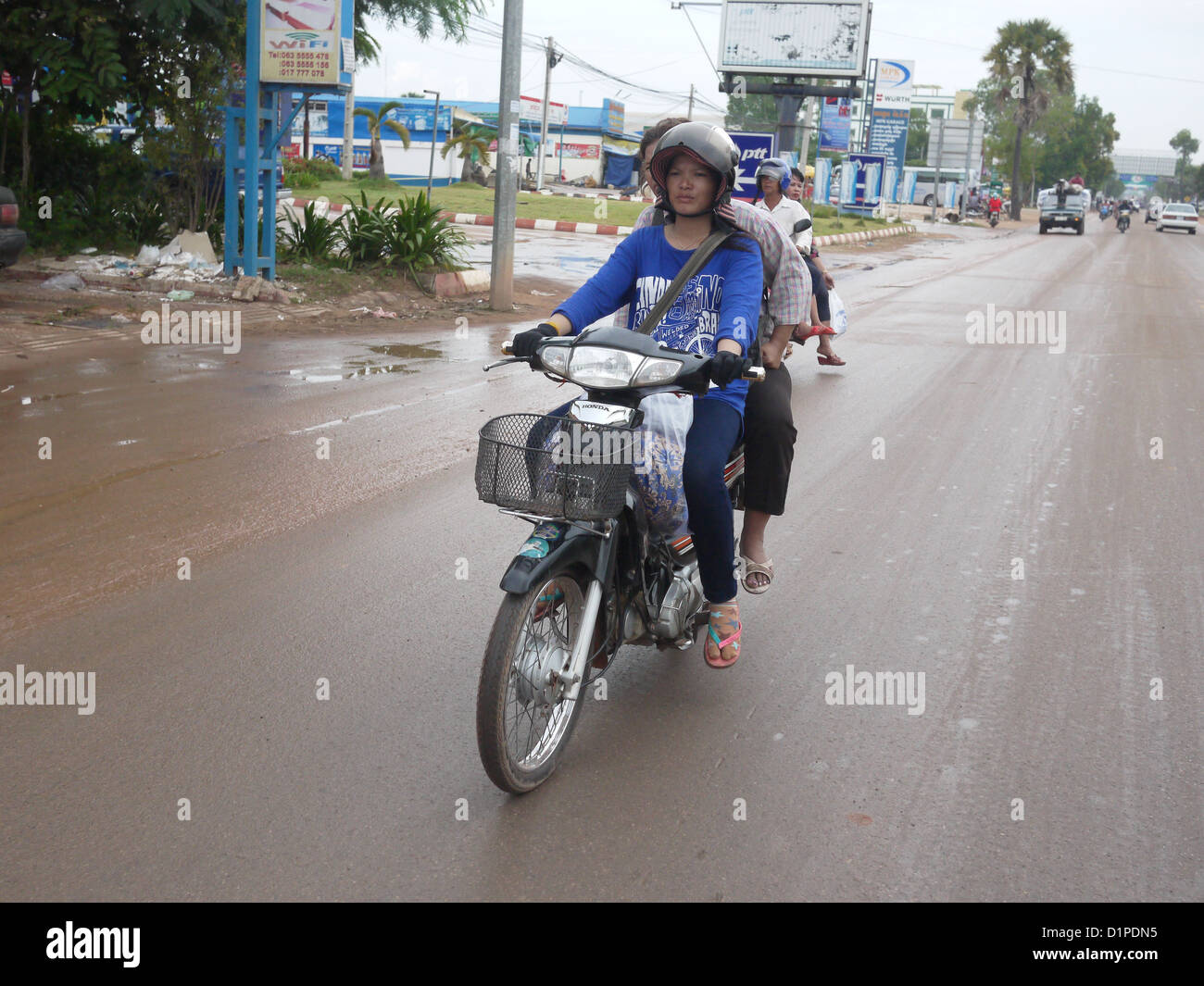Donna asiatica in sella moto paese povero Foto Stock