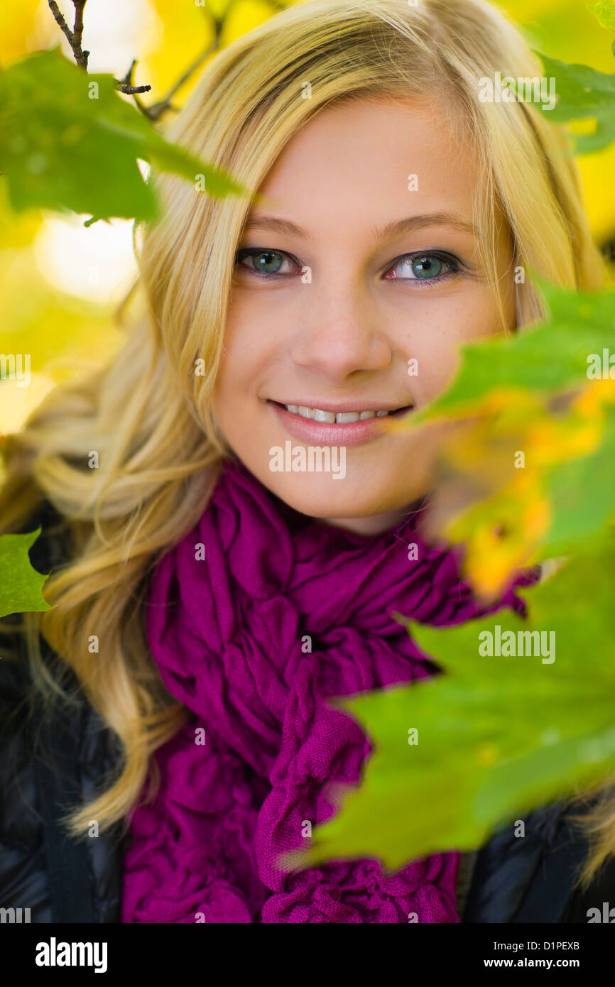 Bella ragazza nel mezzo di foglie, colori dell'autunno Foto Stock