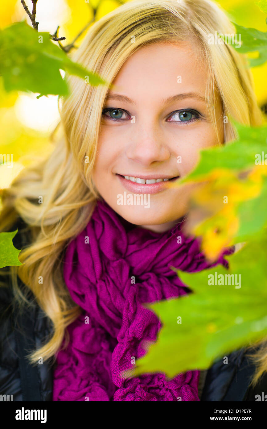 Bella ragazza nel mezzo di foglie, colori dell'autunno Foto Stock