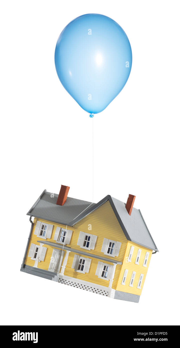 Piccola casa galleggiante con un palloncino. Casa denota crisi immobiliare. Foto Stock