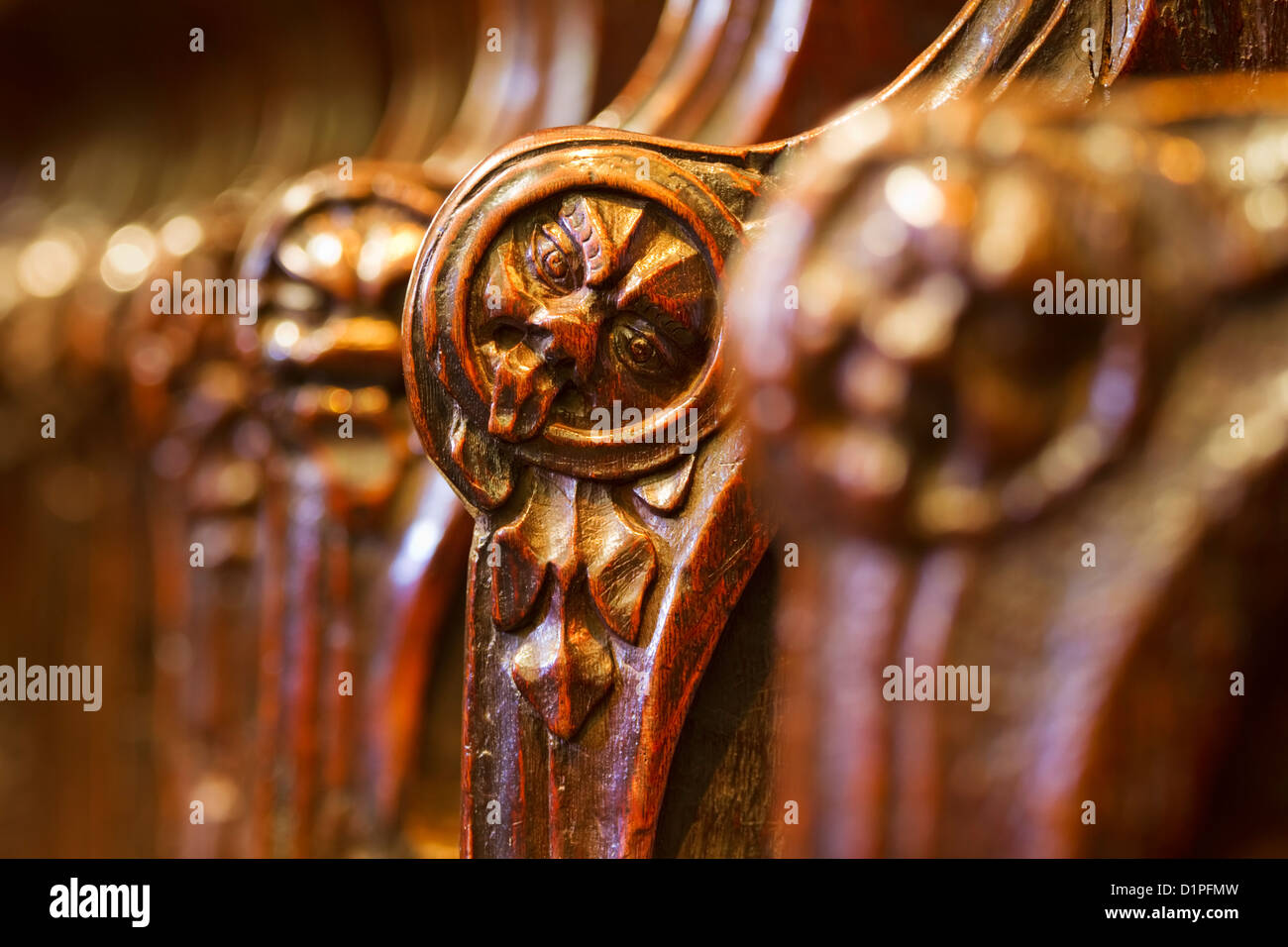 Facce scolpite sui braccioli del tredicesimo secolo inizio inglese coro in Hexham Abbey, Northumberland, Inghilterra Foto Stock