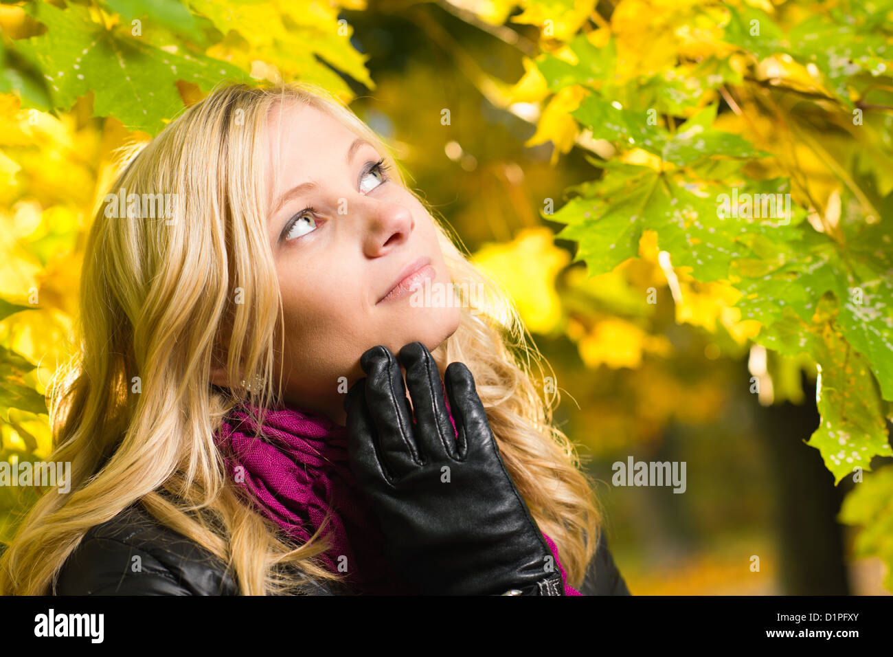 Bella ragazza pone di fronte a un parco, Colore di autunno lascia sullo sfondo, formato con orizzonte di riferimento Foto Stock