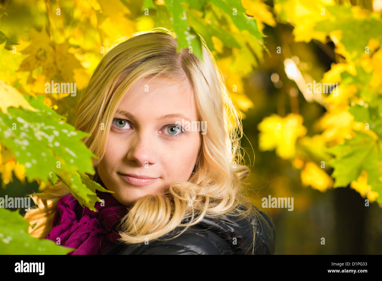Bella ragazza pone di fronte a un parco, Colore di autunno lascia sullo sfondo, formato con orizzonte di riferimento Foto Stock