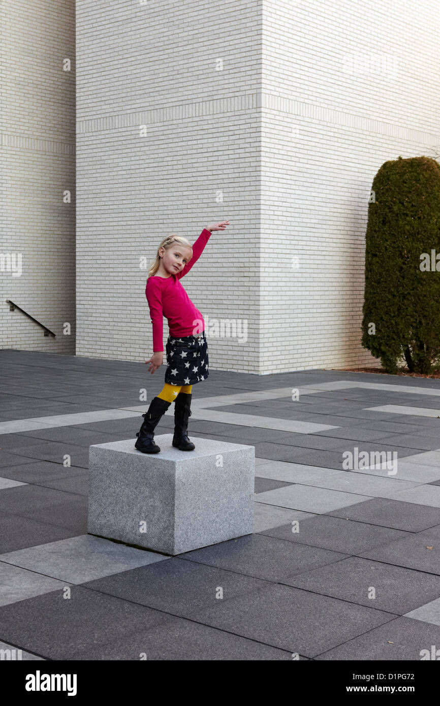 5 anno vecchia ragazza in posa, danza su un piedistallo Foto Stock