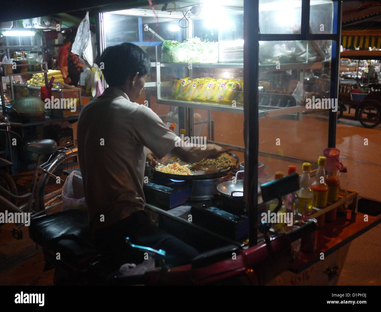 L'uomo la cottura di cibo di strada Siem Reap Cambogia Foto Stock