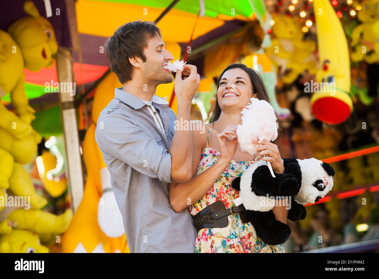 Coppia caucasica condivisione caramella di cotone a carnevale Foto Stock