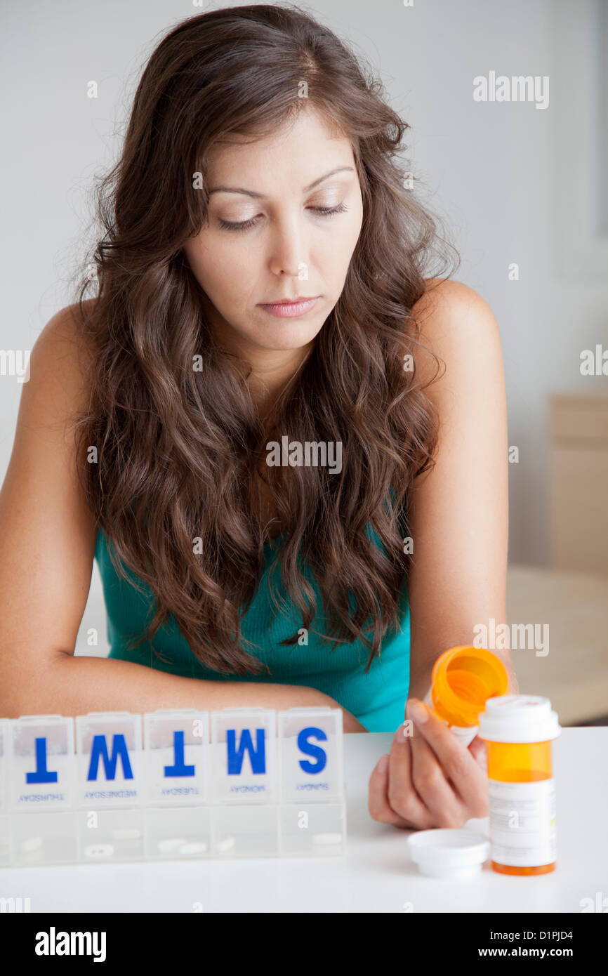 Razza mista donna organizzando pillole Foto Stock