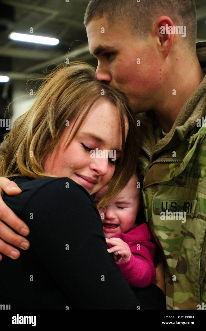 Un U.S. Esercito Nazionale soldato di guardia da 1-211 Brigata Aerea da West Jordan, Utah, saluta la moglie e la figlia dic. 28, 2012, Hill Air Force Base, Utah. Il gruppo è tornato a casa dopo aver trascorso 9 mesi in Afghanistan. Foto Stock