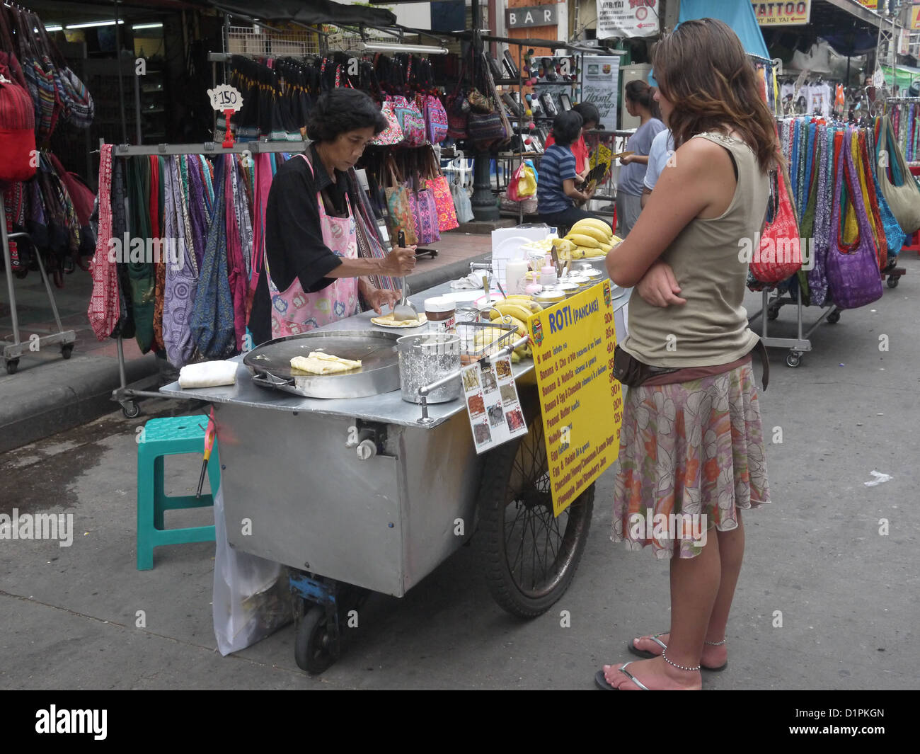La donna in attesa street preparazione alimentare Asia Foto Stock