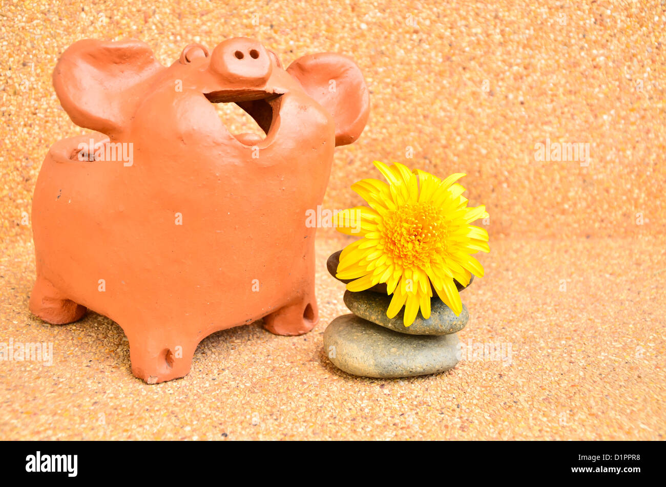 Un maiale statue ridere vicino a fiore . Foto Stock