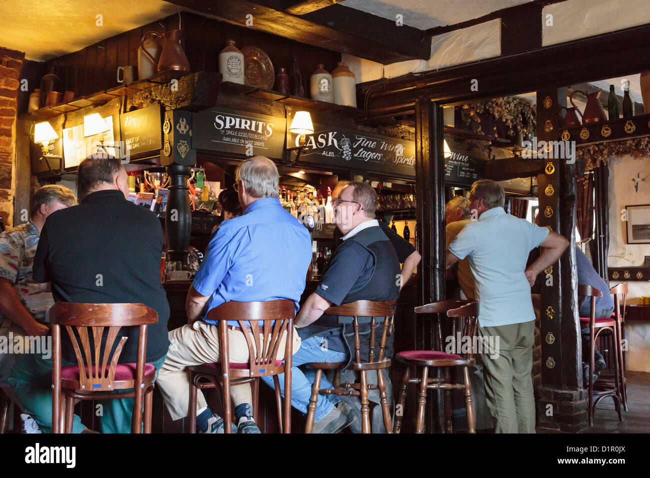 Gli uomini seduti su sedie in corrispondenza di un bar interno haunted xv secolo Old Black Horse pub con travi di legno in Pluckley, Kent, England, Regno Unito Foto Stock