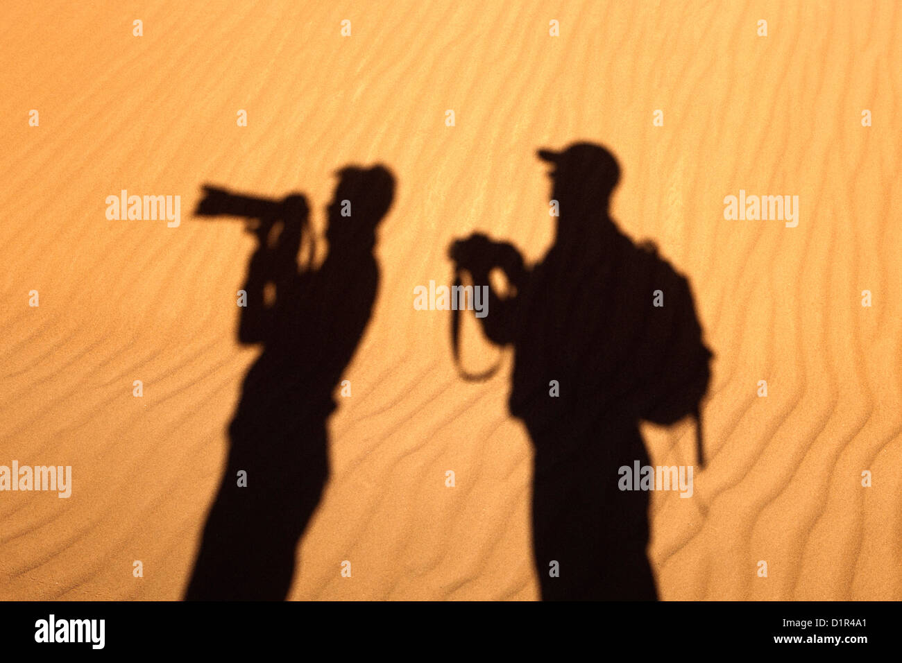 Il Marocco, M'Hamid, Erg Chigaga dune di sabbia. Deserto del Sahara. Silhouette di turista giovane di scattare le foto. Foto Stock
