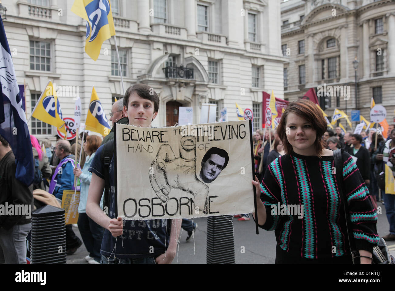 Giovani manifestanti in marzo con una casa fatta di lettura banner attenzione del ladro Osborne. Foto Stock