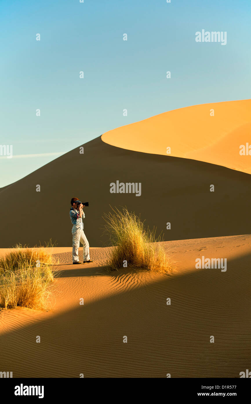 Il Marocco, M'Hamid, Erg Chigaga dune di sabbia. Deserto del Sahara. Fotografo Marjolijn van Steeden prendendo foto sulla duna di sabbia. Foto Stock