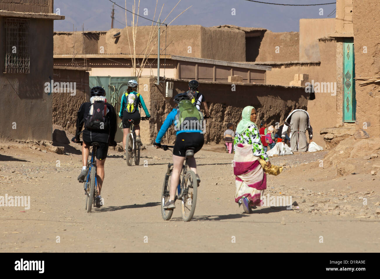 Il Marocco, vicino Agdz, turisti, mountain bike, Escursioni in bicicletta attraverso il villaggio. Foto Stock