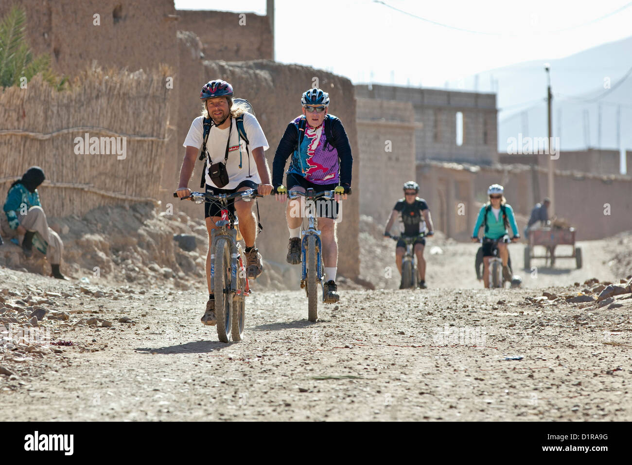 Il Marocco, vicino Agdz, turisti, mountain bike, Escursioni in bicicletta attraverso il villaggio. Foto Stock
