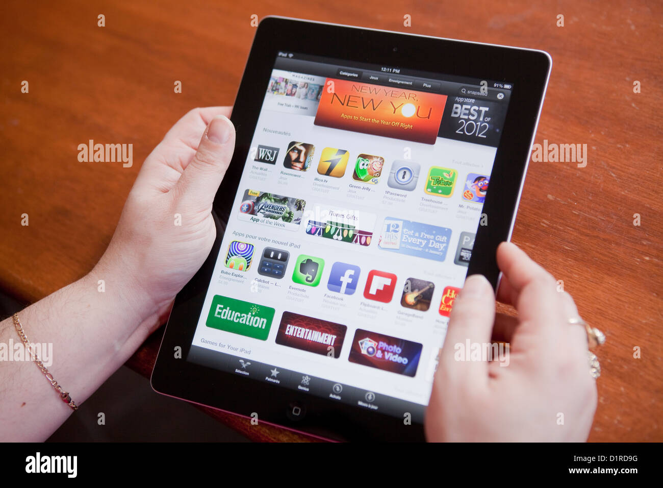 Una donna guarda le App Store su iPad 4 Foto Stock