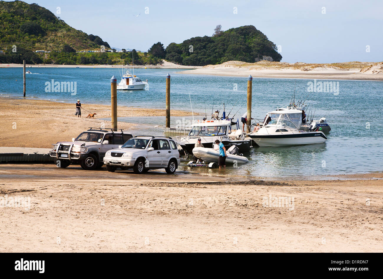 Persone il traino il loro piacere / barche per la pesca al di fuori dell'acqua a scivolo, Mangawhai, Northland e North Island, Nuova Zelanda. Foto Stock