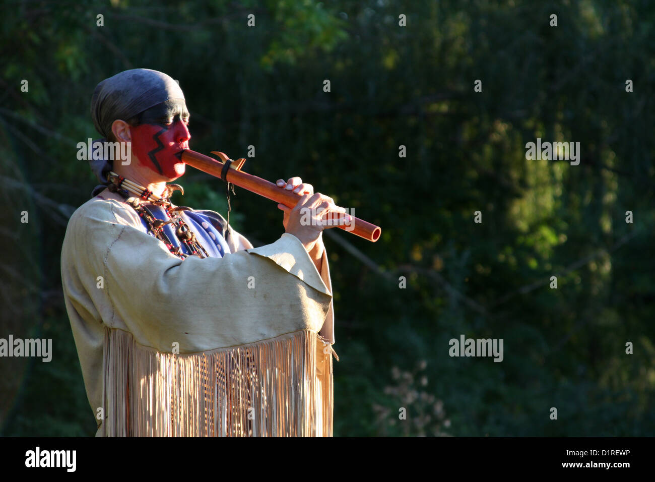Un Native American Indian uomo giocando un flauto al di fuori nella natura Foto Stock