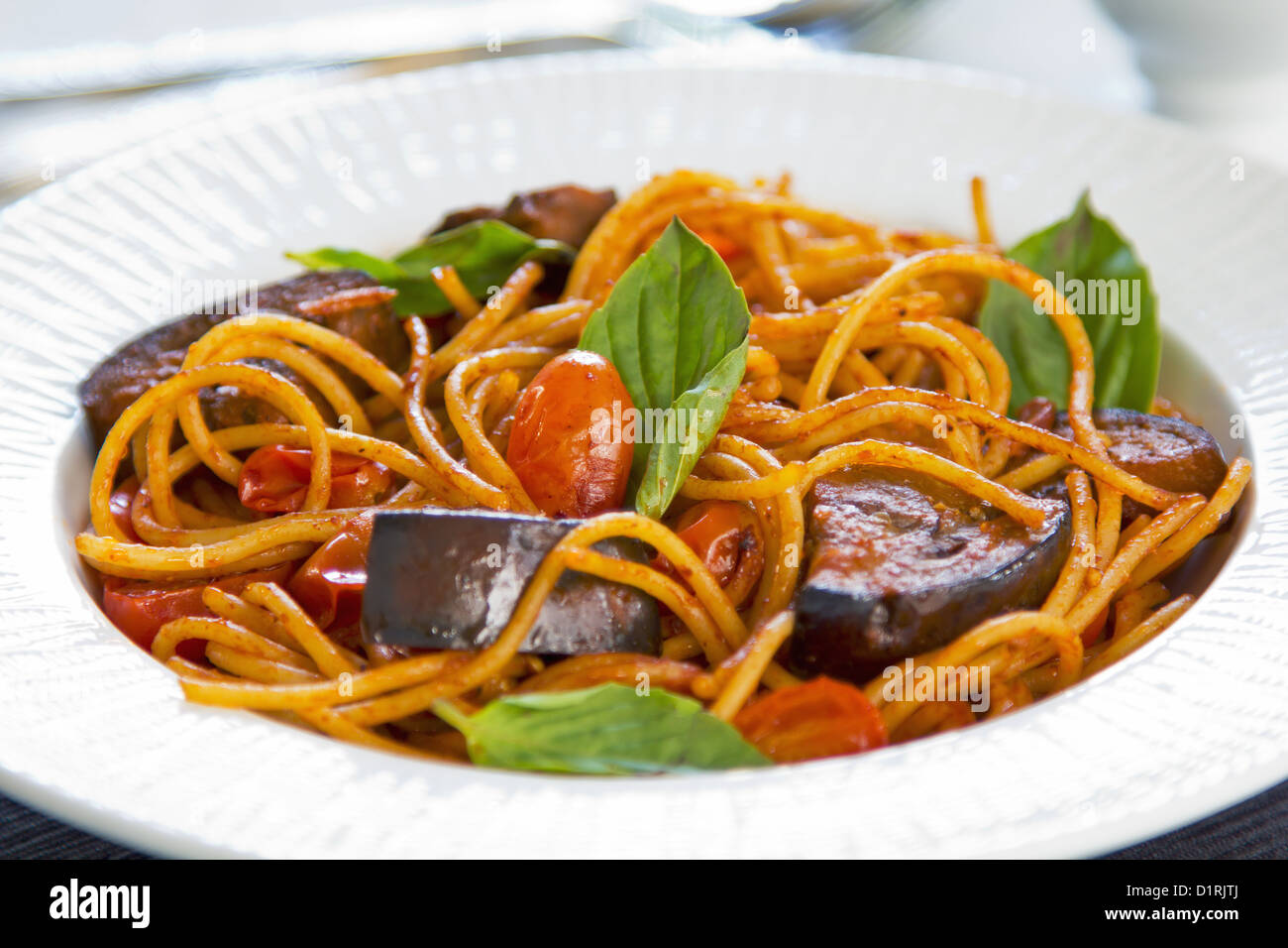 Spaghetti con le melanzane, pomodoro e basilico Foto Stock