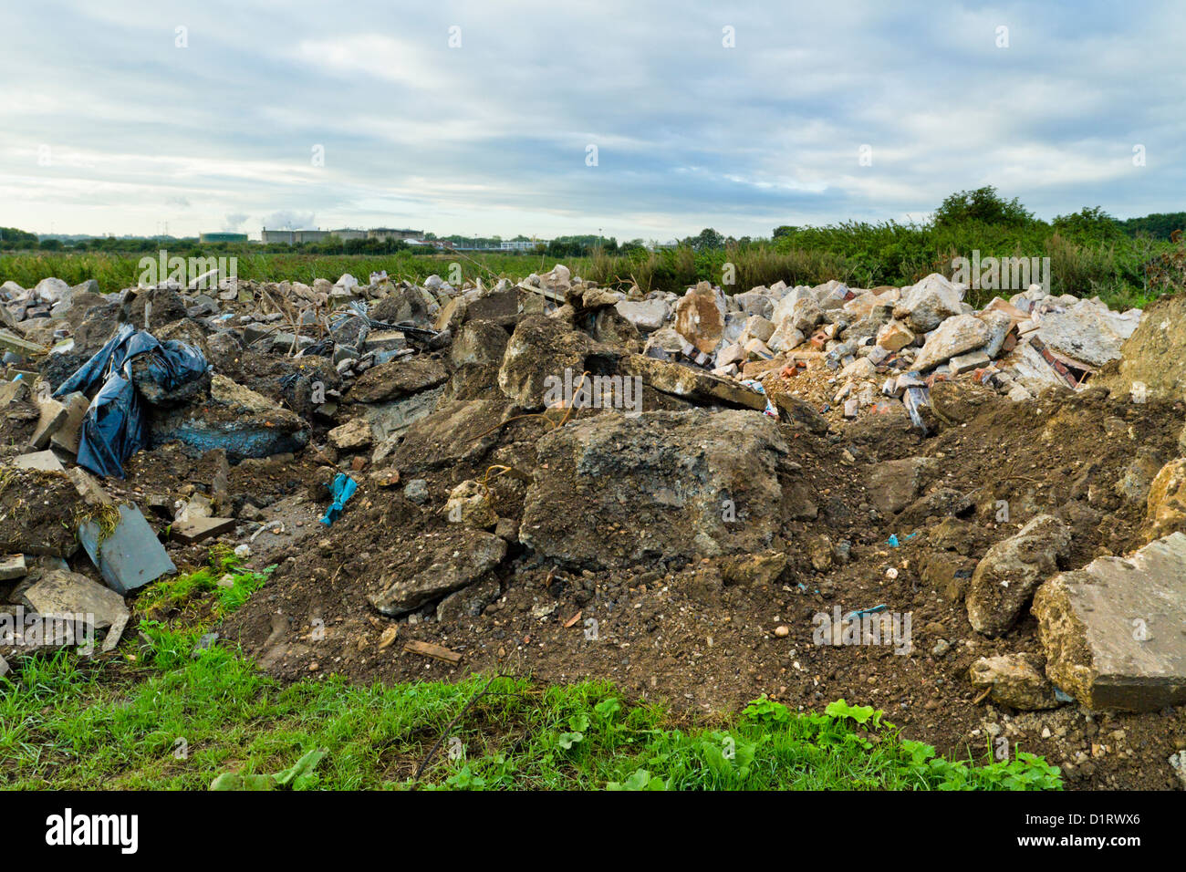 Volare il ribaltamento. Scarico illegale di rifiuti di costruzione su terreno coltivato, Nottinghamshire, England, Regno Unito Foto Stock