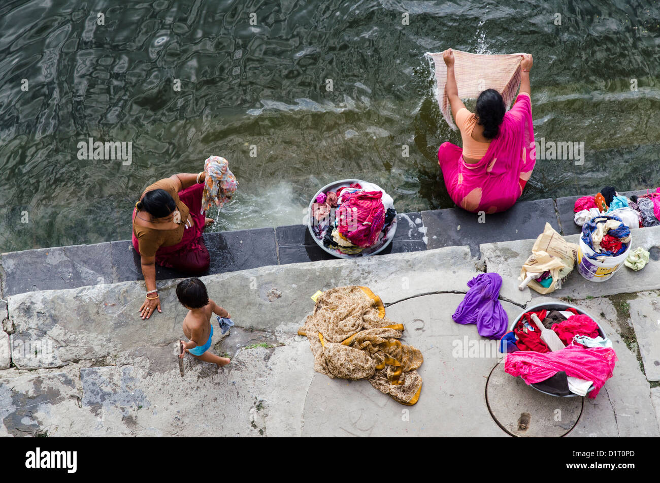 Lavandaie il lavaggio della biancheria nel lago Pinola, Udaipur, Rajastan, India Foto Stock