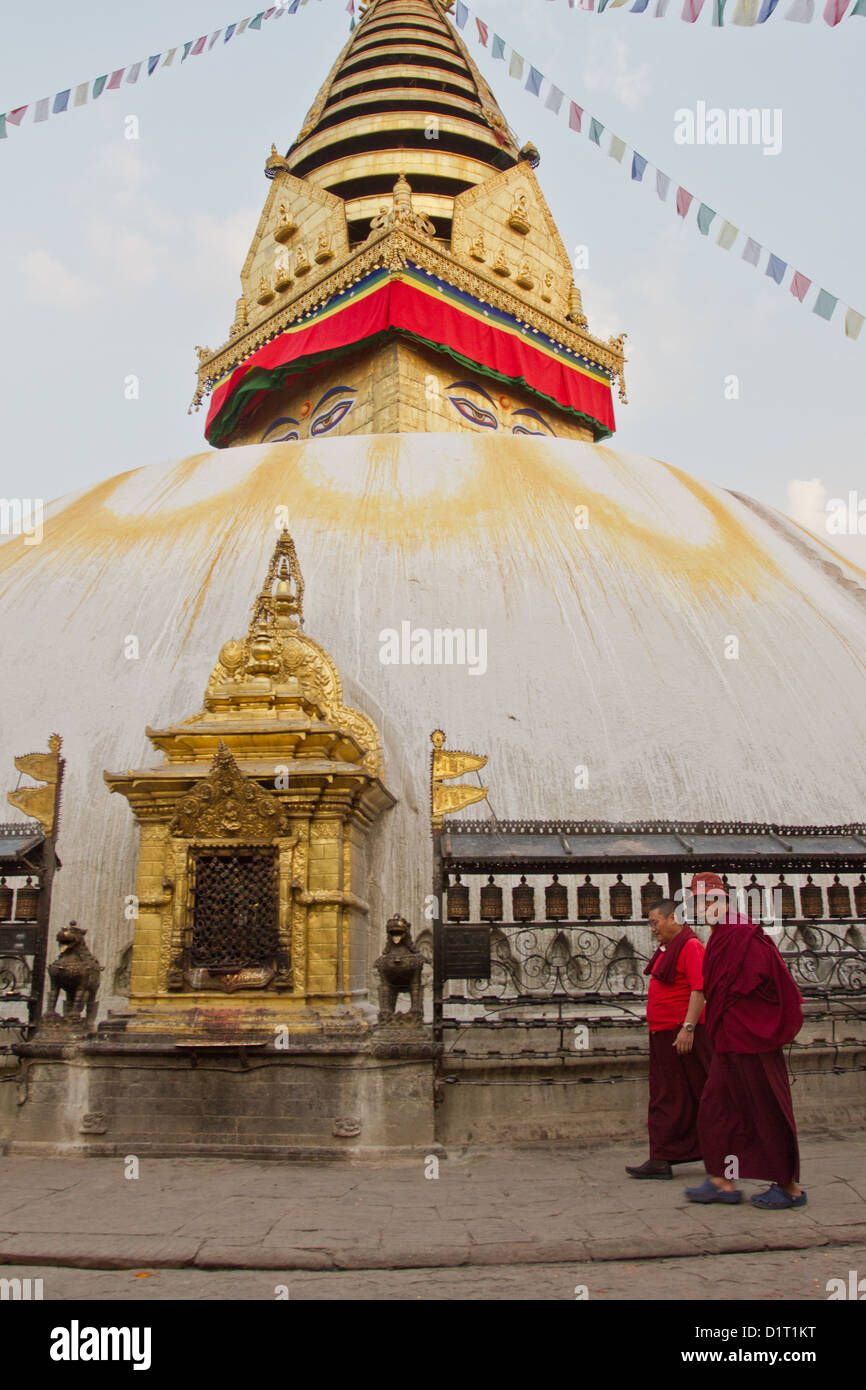 I monaci a piedi passato ruote della preghiera attorno alla stupa al tempio Boudhanath Kathmandu in Nepal Foto Stock