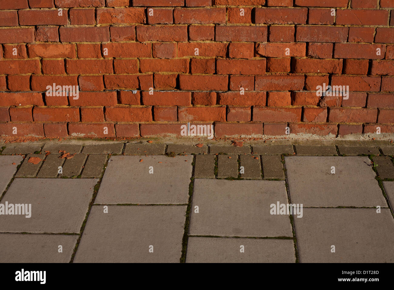 In mattoni rossi incontra il muro di pietre per pavimentazione marciapiede Foto Stock