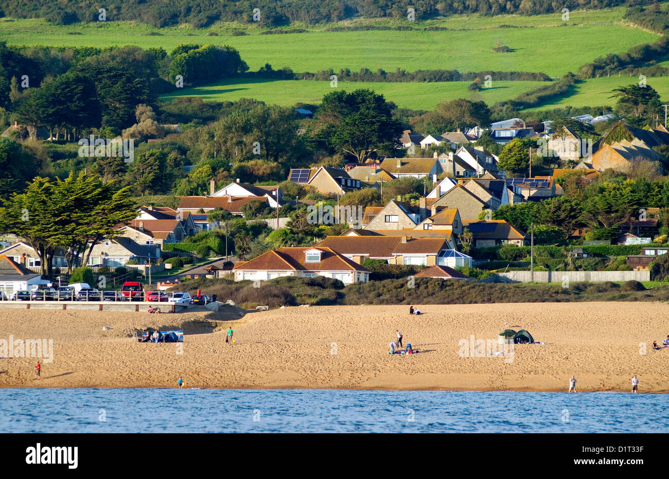 Case a West Bexington, Dorset, capovolto giù per la collina per il Chesil Beach, fotografato da una barca nella baia di Lyme Foto Stock