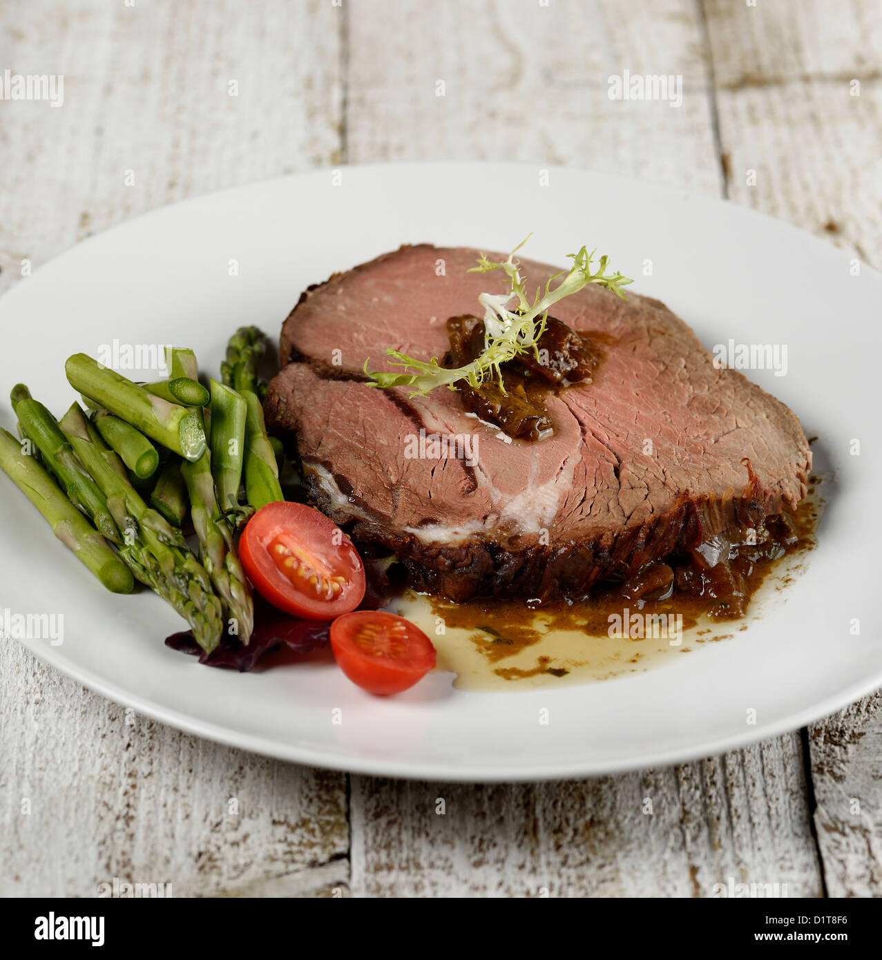 Fetta di arrosto di manzo con asparagi e pomodori Foto Stock