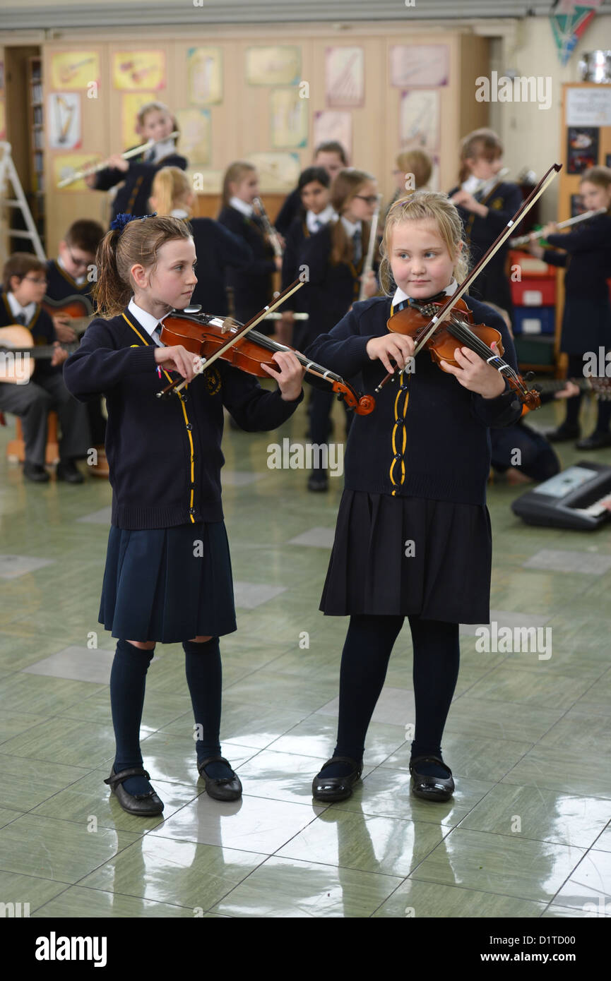 Due ragazze la riproduzione di violini a una lezione di musica la Madonna e San Werburgh Cattolico della scuola primaria a Newcastle-under-Lyme, Staffords Foto Stock