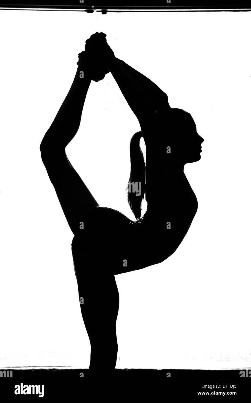 In bianco e nero la silhouette di un giovane ginnasta tenendo un scorpian pongono. Foto Stock