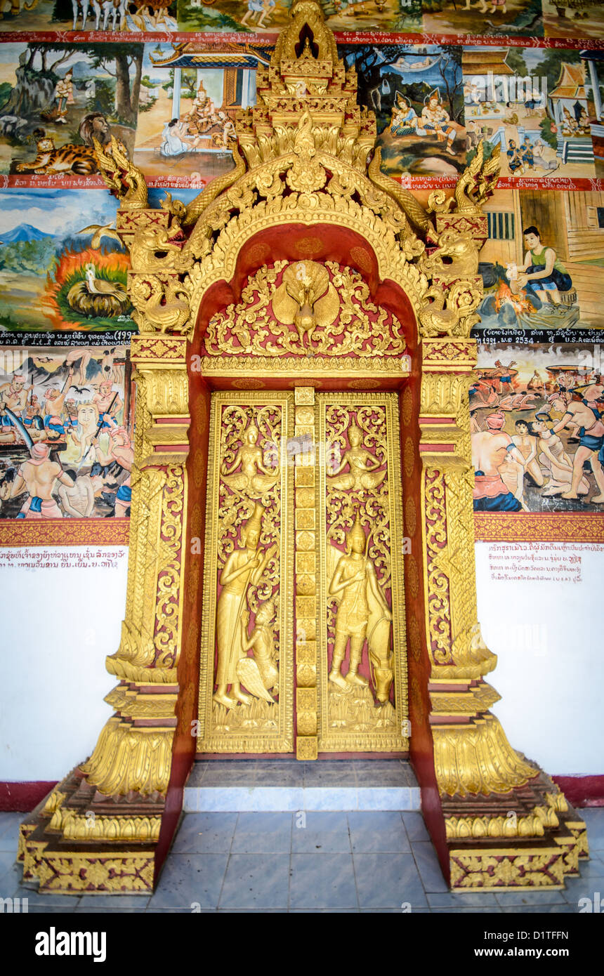 LUANG Prabang, Laos - una porta guilded circondato da ornati dipinti sulla parte esterna di Wat Phonxay Sanasongkham a Luang Prabang, Laos, vicino al mercato di mattina. Foto Stock