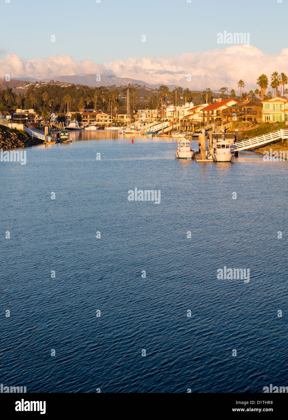 Tramonto su sviluppo residenziale da acqua a Ventura California con case moderne e yacht barche Foto Stock