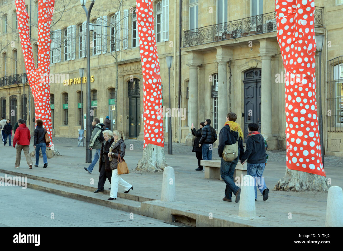 Pedoni passavano oltre gli alberi di platano avvolti di Polka Dot, un'installazione artistica dell'artista giapponese Yayoi Kusama Cours Mirabeau Aix-en-Provence per l'inaugurazione di Marseille-Provence 2013 capitale europea della Cultura. Provenza Francia Foto Stock