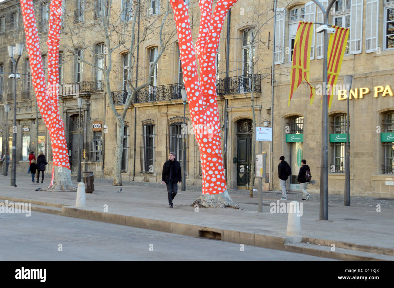 Pedoni passavano oltre gli alberi di platano avvolti di Polka Dot, un'installazione artistica dell'artista giapponese Yayoi Kusama Cours Mirabeau Aix-en-Provence per l'inaugurazione di Marseille-Provence 2013 capitale europea della Cultura. Provenza Francia Foto Stock