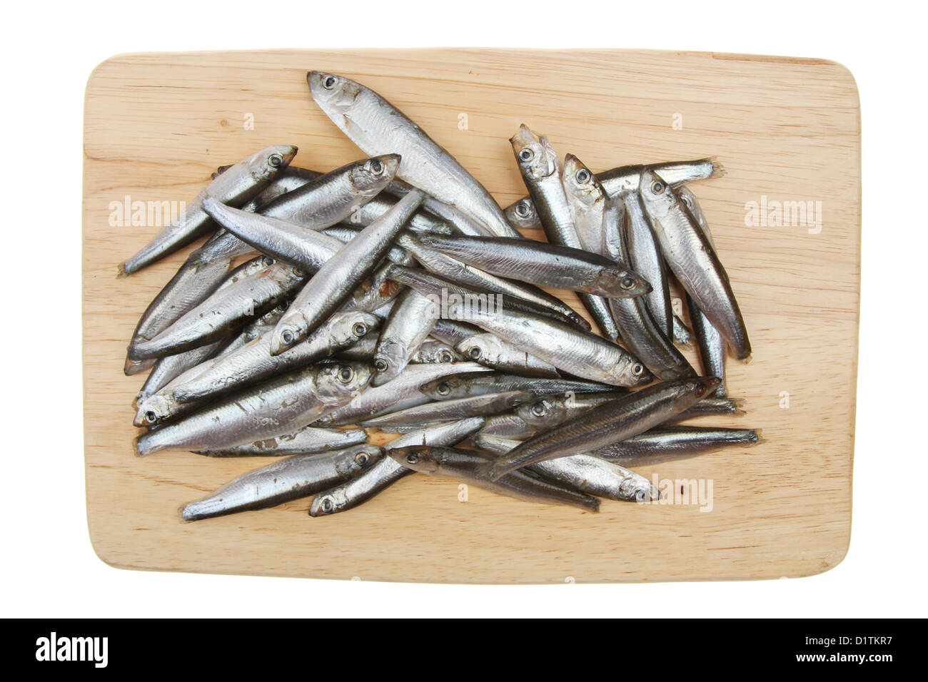 Piccole materie bianchetti pesce su una tavola di legno isolata contro bianco Foto Stock