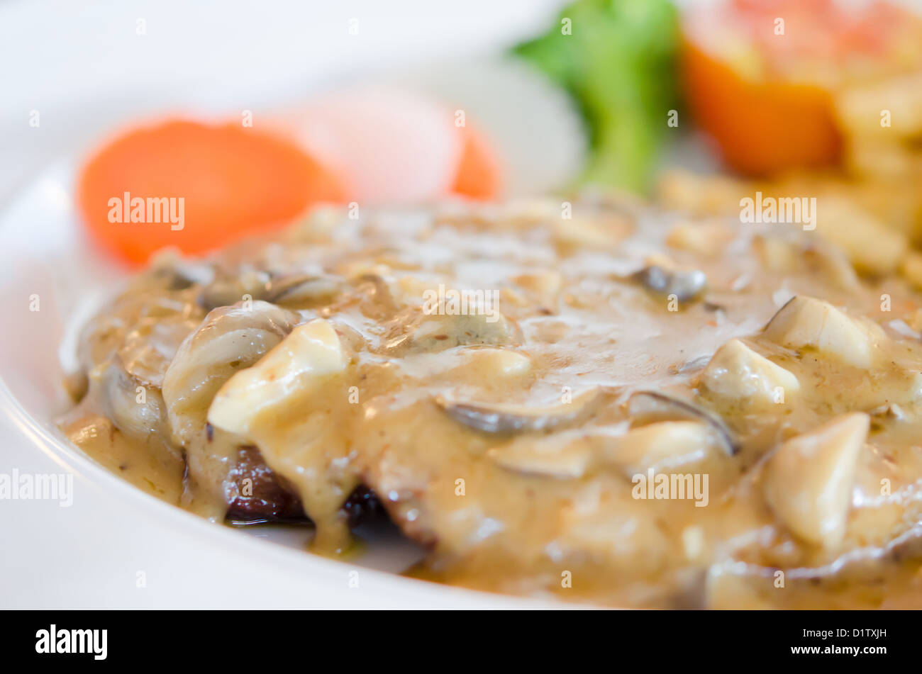 Close up bistecca di manzo con salsa di funghi sulla piastra Foto Stock