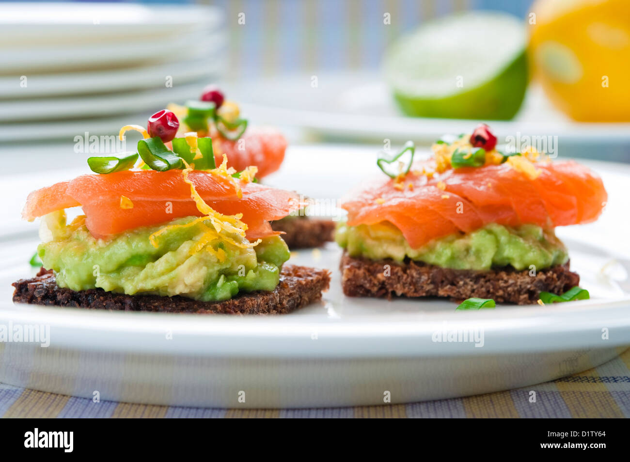 Marrone sandwich di pane con salmone affumicato, avocado e rabboccato con erba cipollina e pepe Foto Stock