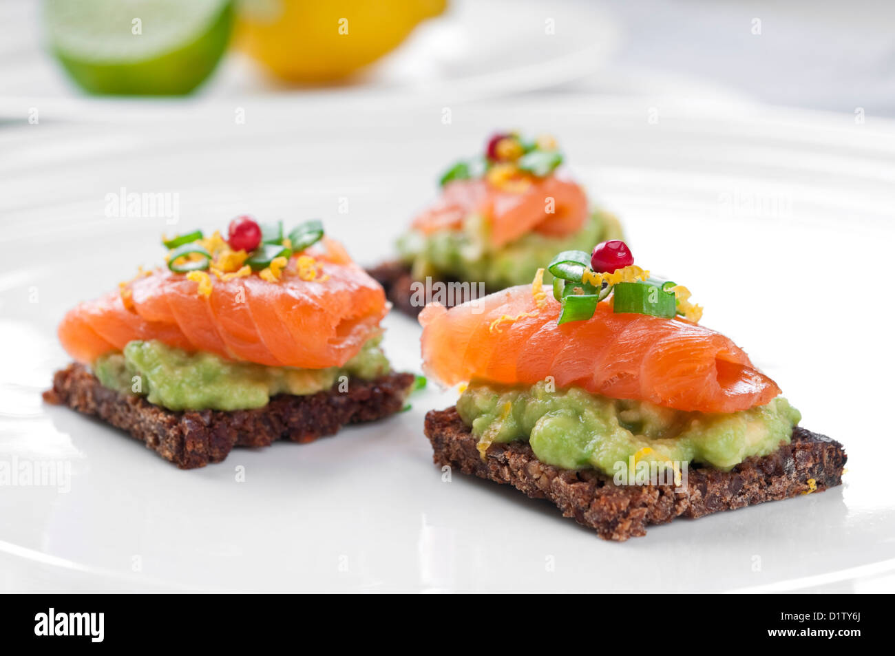 Marrone sandwich di pane con salmone affumicato, avocado e rabboccato con erba cipollina e pepe Foto Stock