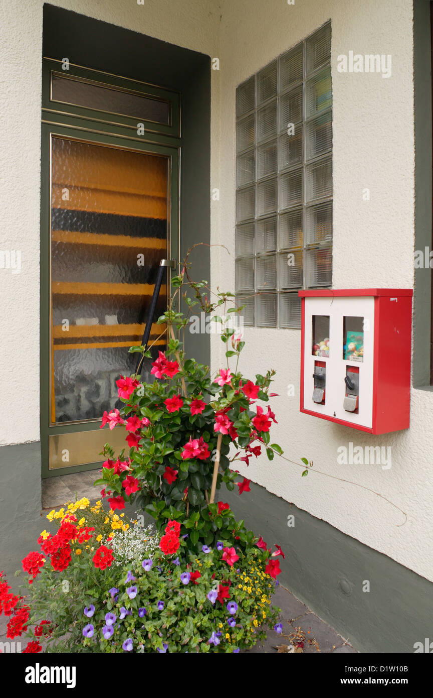 New Castle, Germania, un ingresso di casa con fiori e una macchina gumball Foto Stock