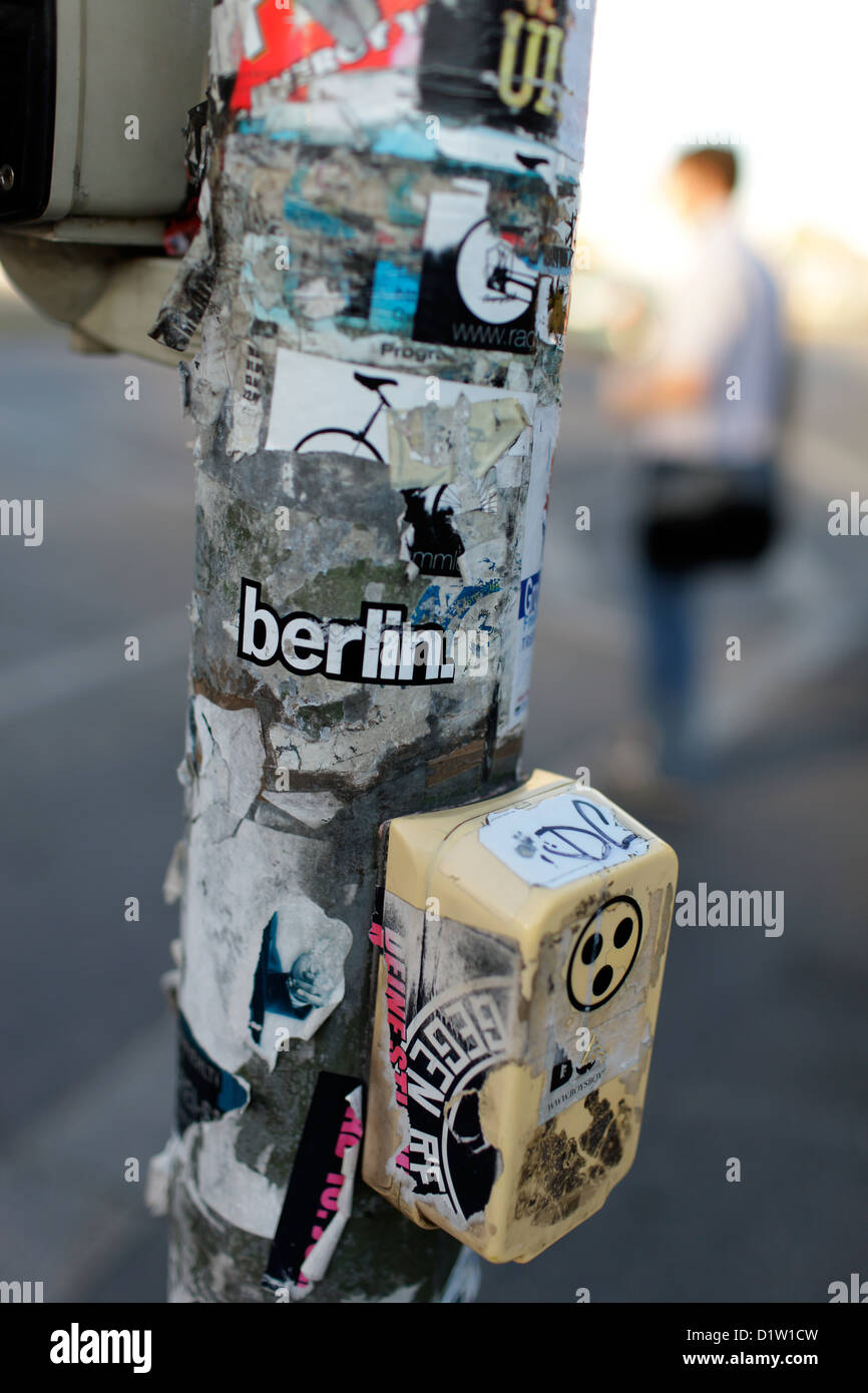 Berlino, Germania, con lettura di etichette di Berlino e interruttori per il cieco su un semaforo con un palo della luce Foto Stock